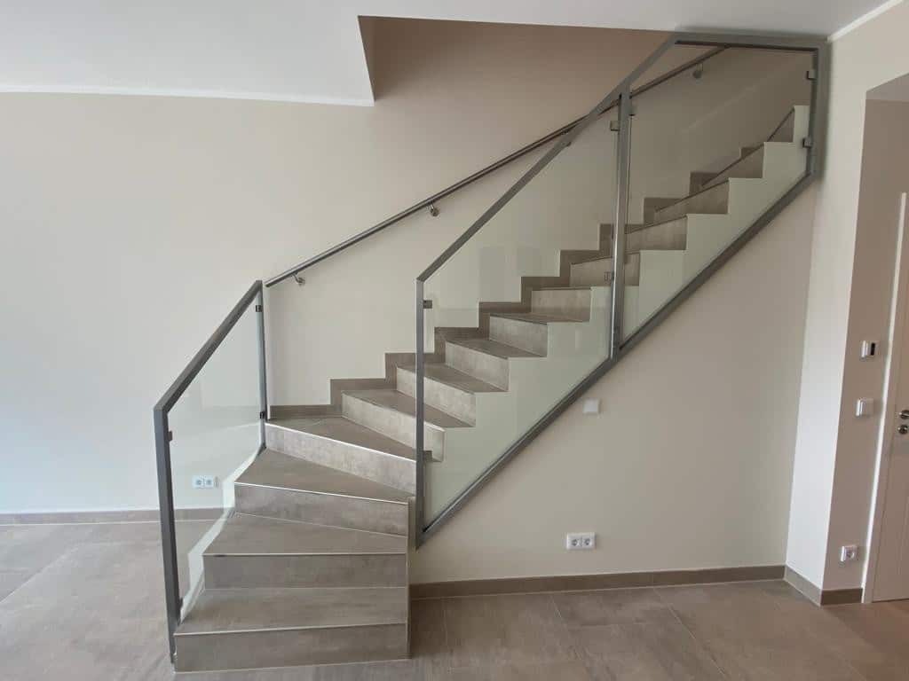 Langlebiges Treppengeländer aus pulverbeschichtetem Stahl mit horizontalen Streben aus perforiertem Metall. Sorgt für Stabilität und Sicherheit.